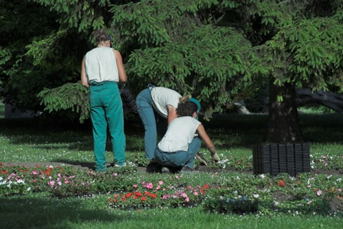 Garden maintenance worker using protective clothing and tools safely